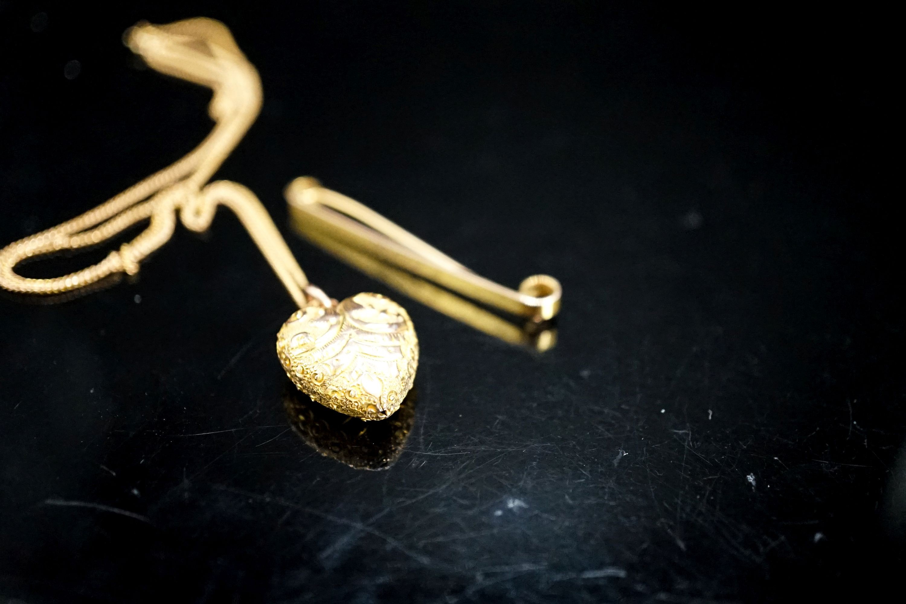 A 9ct tie pin and a yellow metal heart shaped pendant on a 9c fine link chain, gross weight 5.9 grams.